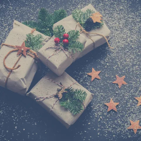 Regalos envueltos en papel kraft con ramitas de pino y estrellas